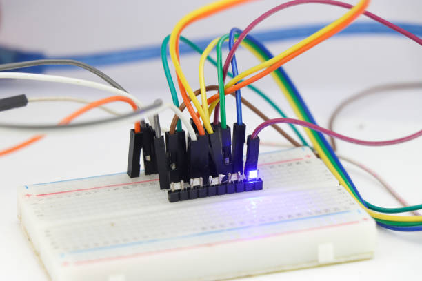 istock Group of SMD led on a breadboard connected with jumper wires and emitting a blue light 1532970779