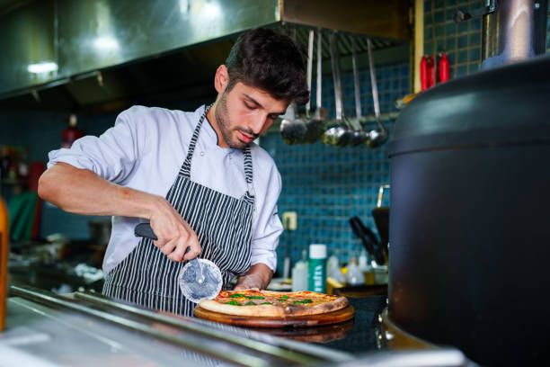 istock Chef preparing pizza in kitchen next to oven 1532971907
