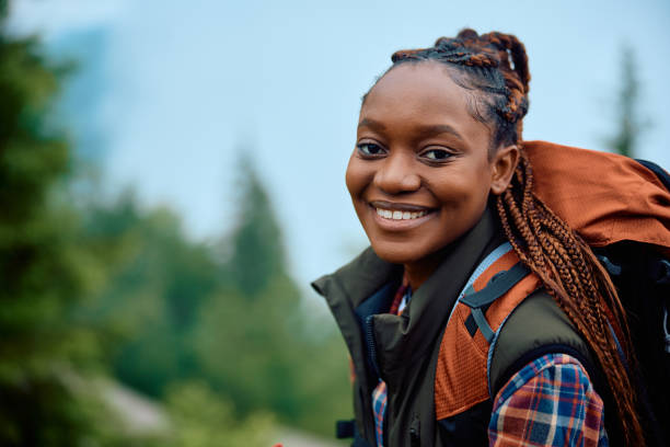 istock Happy black female backpacker in nature looking at camera. 1532987901