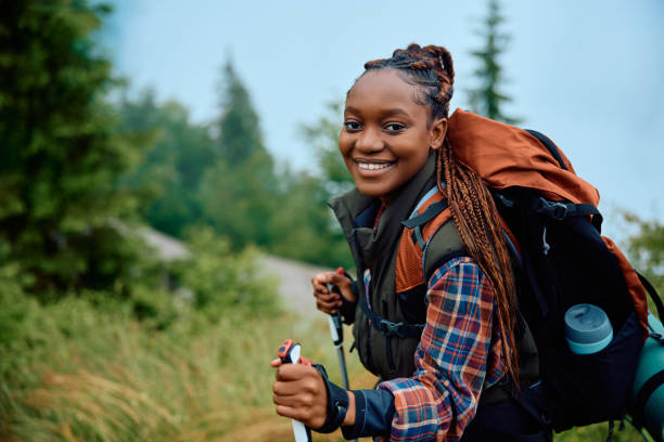istock Happy black female hiker on a hill looking at camera. 1532987916