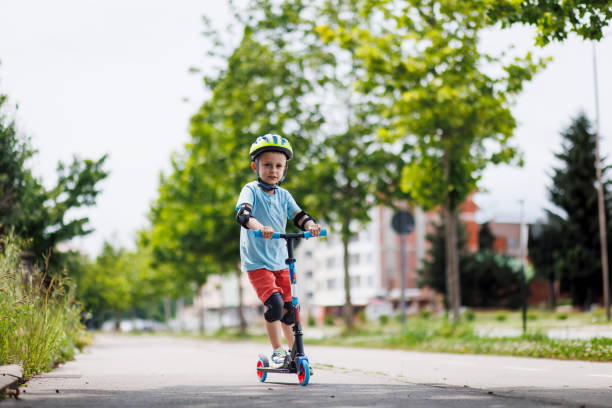 istock Kid with helmet riding push scooter 1533033304