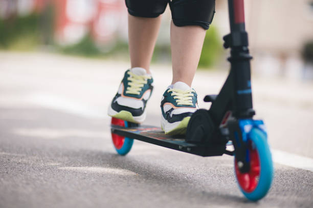 istock Child riding on scooter on asphalt road in summer. 1533034256