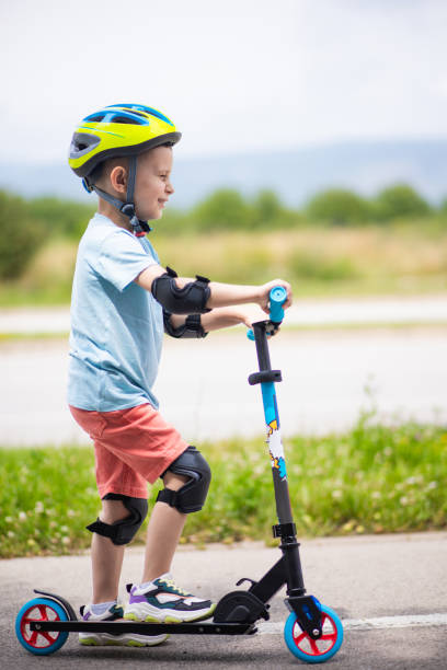 istock Kid with helmet riding push scooter 1533038985