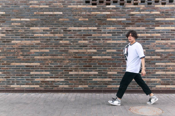 istock young man walks down the street in front of a brick wall 1533044290