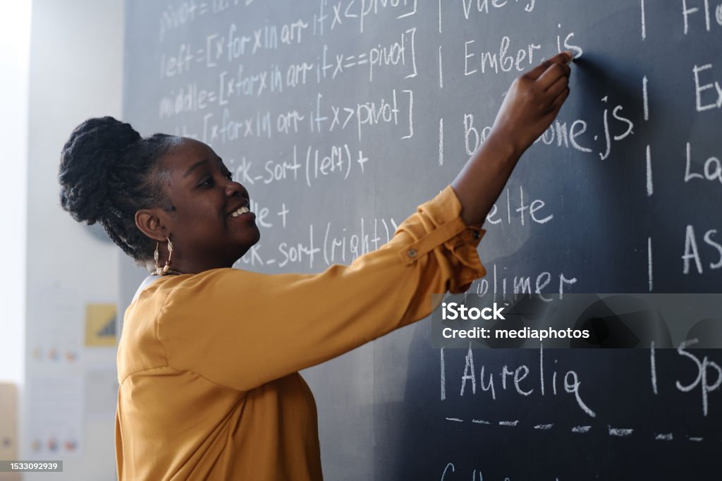 Teacher writing formulas on blackboard - Royalty-free 25-29 jaar Stockfoto Teacher writing formulas on blackboard - Royalty-free 25-29 jaar Stockfoto