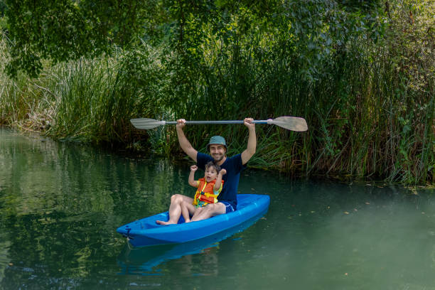 giovane padre e il suo bambino che fanno kayak insieme - exploration curiosity nature canoeing foto e immagini stock