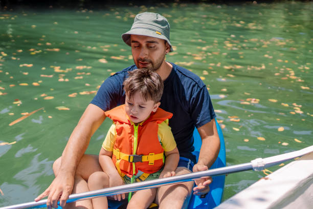 giovane padre e il suo bambino che fanno kayak insieme - exploration curiosity nature canoeing foto e immagini stock