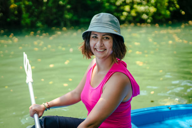 kayak di pagaiata della donna nel fiume e ridere - exploration curiosity nature canoeing foto e immagini stock