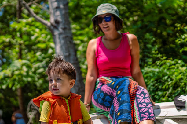 madre che prepara il suo figlio per il kayak - exploration curiosity nature canoeing foto e immagini stock