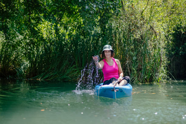 kayak di pagaiata della donna nel fiume e ridere - exploration curiosity nature canoeing foto e immagini stock