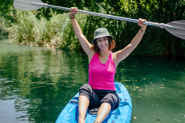 kobieta wiosłująca kajakiem w rzece i śmiejąca się - exploration curiosity nature canoeing zdjęcia i obrazy z banku zdjęć