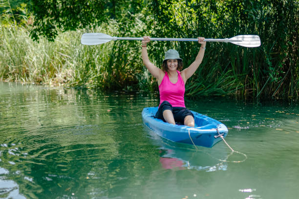 kayak di pagaiata della donna nel fiume e ridere - exploration curiosity nature canoeing foto e immagini stock