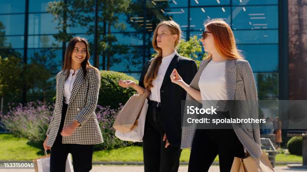 Kuvapankin valokuva otsikolla Hymyilevät Suuret Karismaattiset Kauniit Naiset Hyvän Ostoksen Jälkeen Kävelemällä Kadulla Keskustelemassa Yhdessä Ja Onnellisesti Pitämällä Ekoostoslaukkuja Taustalla Hämmästyttävä Korkea Rakennus – Lataa kuva nyt