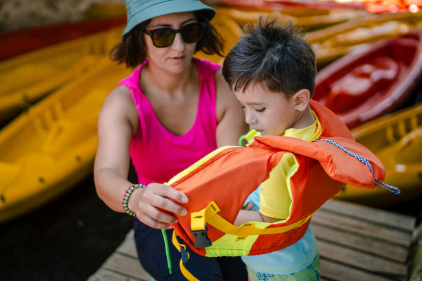 matka przygotowuje syna do spływu kajakowego - exploration curiosity nature canoeing zdjęcia i obrazy z banku zdjęć