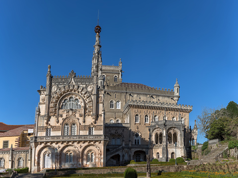 Luso / Aveiro / Portugal - 03 09 2019 : Full view of the back facade of the Bussaco Palace, Romantic palace in Neo-Manueline style monument, romantia« classic gardens and blue sky, in Portugal