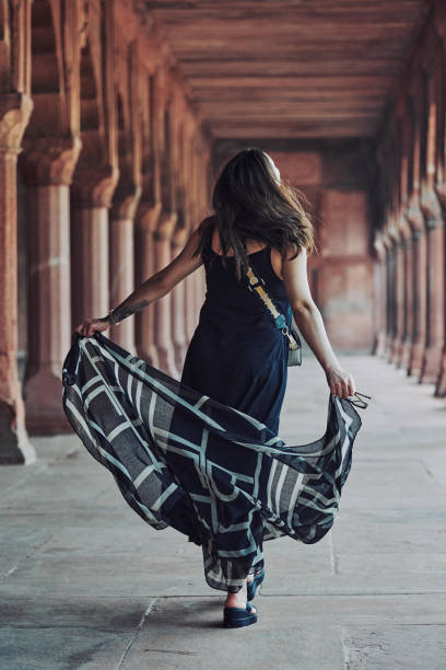 east asian woman in black dress dancing with translucent scarf among columns of ancient temple - taj mahal mahal door temple imagens e fotografias de stock