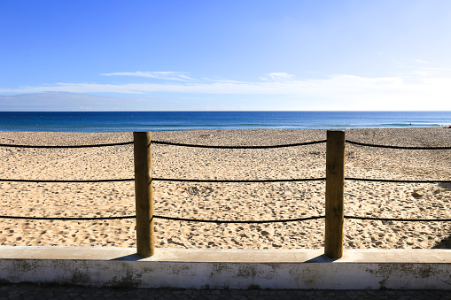 Wooden and rope fence on lonely Salema Beach in Algarve, Portugal