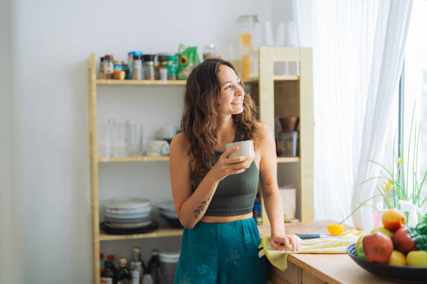 istock Woman standing on the kitchen and drinking freshly made mint lemon tea 1533248581