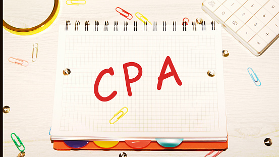 A CPA, a Certified public Accountant or a cost-per-action concept, the word CPA written on a notebook, a certificate used for auditing accounting, or an online advertising term to denote the costs paid for a user's action.