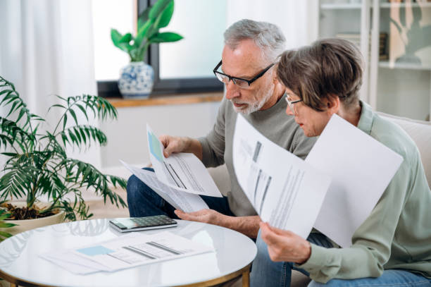 Elderly couple checking documents with tax and internal bills stock photo