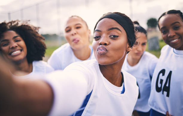 netball, selfie et portrait d’étudiantes sur un terrain de sport extérieur pour un match ou une séance d’entraînement. faire de l’exercice, embrasser le visage et regrouper les athlètes pour le sport, le bien-être des élèves et le travail d� - club détudiantes photos et images de collection