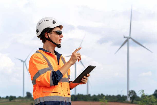 Expertise of engineer utilizes digital tablet to assess and inspect the operational status of wind turbine in turbine farm. Focus on technology, wind power, and environmental conservation is evident. Adorned in professional attire and equipped with essential safety gear. la experiencia del ingeniero utiliza una tableta digital para evaluar e inspeccionar el estado operativo de la turbina eólica en el parque de turbinas. el enfoque en la tecnología, la energía eólica y la conservación del medio ambiente es evidente.