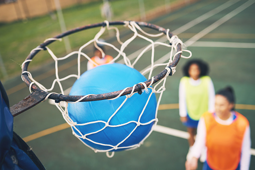Ball in net, netball and sports outdoor with team, fitness and active lifestyle with athlete on court. Sport, professional club and people playing game, success with goal and exercise with training