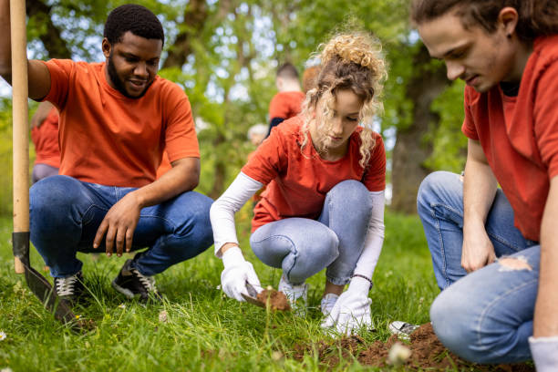 istock Group of young people digging a hole for planting a tree 1533433453