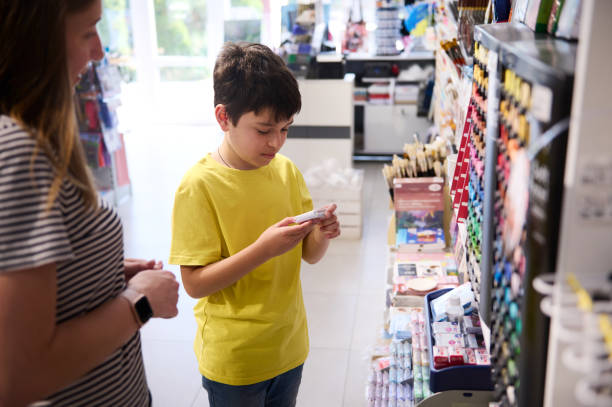 Adorable teenage boy choosing a modeling clay in a school stationery store. People. Creative hobby. Education. Fine art stock photo