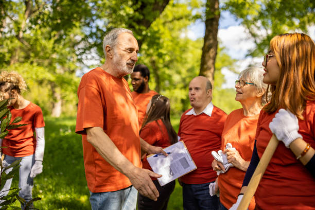 Senior Caucasian man organizing a group of activists in a forest
