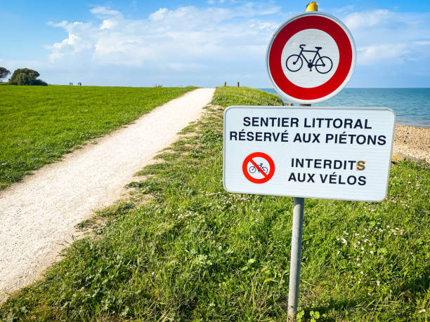 "Coastal path prohibited for bicycles" French sign on the coast of the Ré island in La Flotte "Coastal path prohibited for bicycles" French sign on the coast of the Ré island in La Flotte, France flotte stock pictures, royalty-free photos & images