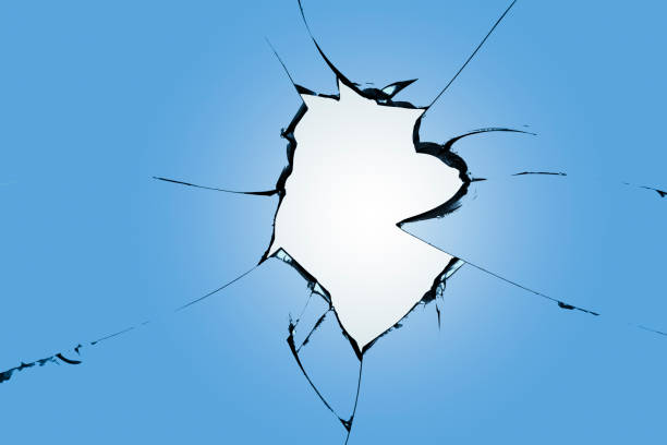 istock Cracks on the blue glass, a broken window after shelling. Effect of destruction during shelling 1533483666