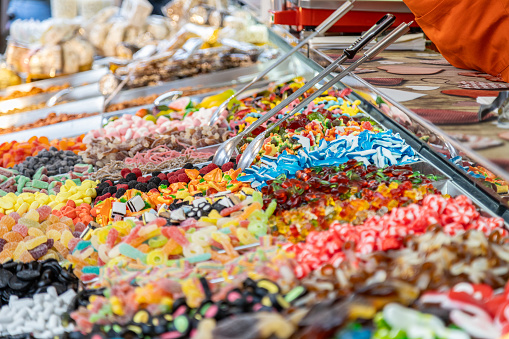 View of delicious colorful candies with a scoop on counter of a Italian confectionery shop