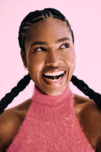 ecstatic and vibrant black woman rocking her cornrows and monochromatic pink look. stock photo