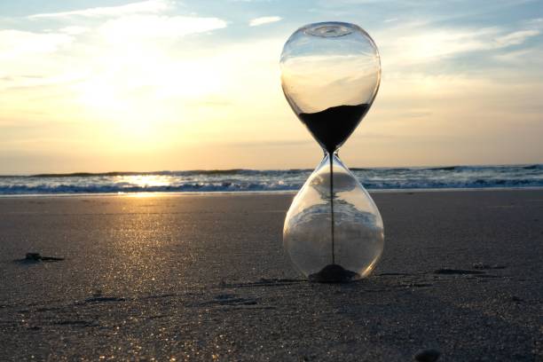 istock sand flows into an hourglass on the beach at sunset 1533573859