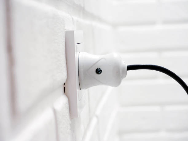 istock Electric plug and socket on white brick wall background, power energy concept 1533575968