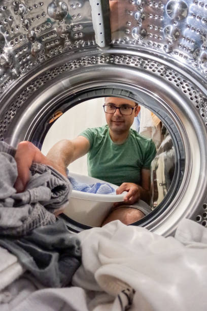 istock Mid Adult Man Putting Laundry In A Washing Machine 1533576486