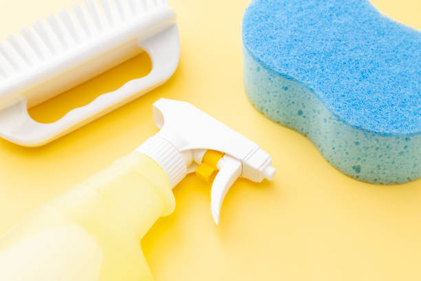 istock Cleaning supplies on yellow background 1533595156