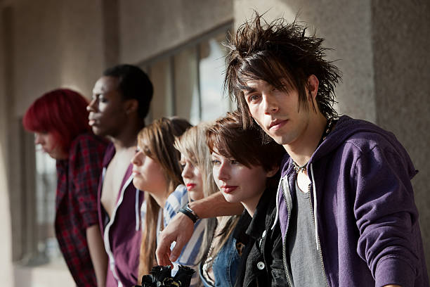Young Punk Stares Young punk boy looks at the camera as his friends look away into the distance. gang photos stock pictures, royalty-free photos & images
