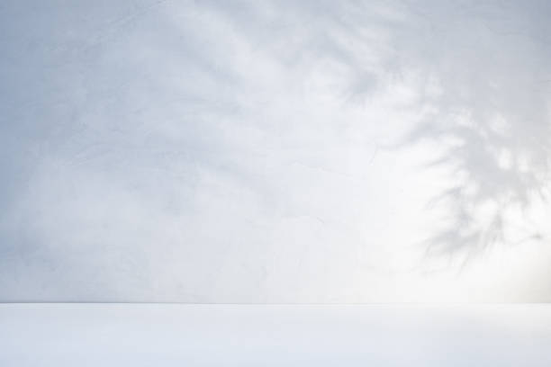 istock White table top and concrete wall with shadow from branches with leaves in sunlight 1533611661