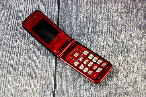 Classic mobile phone, flip.Retro folding cell phone. Old-fashioned push-button mobile wireless phone vintage.Folding phone with buttons.