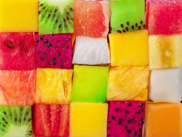 istock Fruit puzzle. Colorful food background or pattern arranged of different fruit cubes. Dietary concept. 1533625150