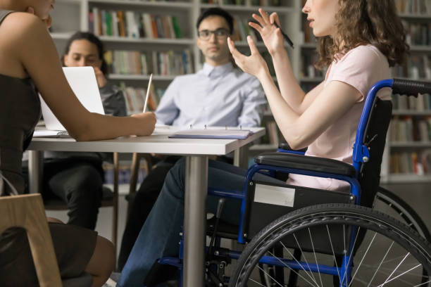 istock Team of students and speaker with disability meeting in library, 1533629642
