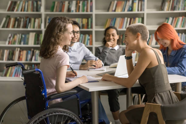 istock Young student with disability cooperating on project with college friends 1533629661