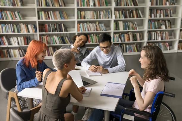 istock Group of students and classmate with disability studying in library 1533629664