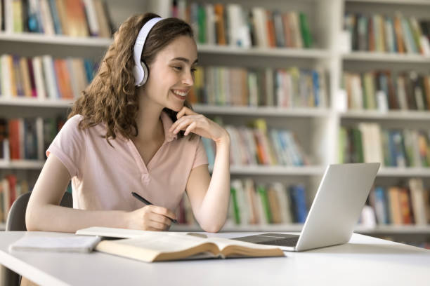 istock Cheerful university student girl working on research study in library 1533630497