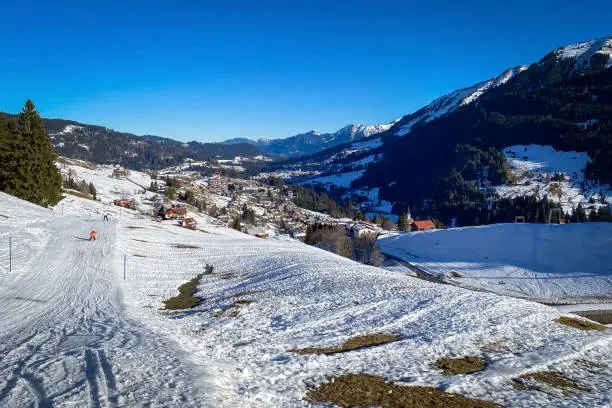 Scenic view of snow coverd Hirschegg at ski region of  Kleinwalsertal, Austria in winter against blue sky