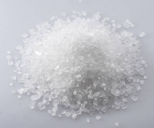 istock Pile of salt crystals on white background. Top view. 1533636370