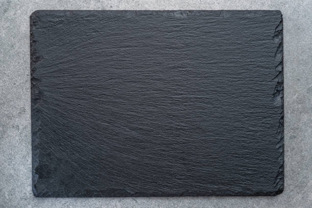istock Empty natural stone black slate serving plate on light grey background. Flat lay. 1533637549