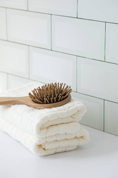 istock Wooden comb with white towel. tile wall background. 1533651500